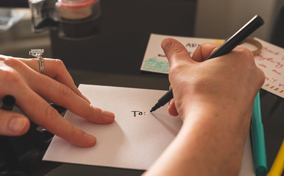 Image description: A person holding a pen and writing a letter addressed to their favorite celebrity.