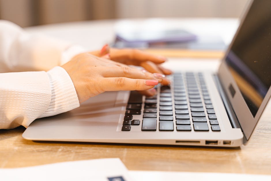 A person typing a fan mail message on a laptop keyboard